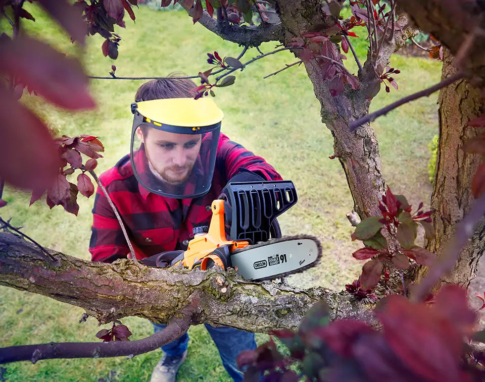 LawnMaster Chainsaw cutting a tree branch in irish garden