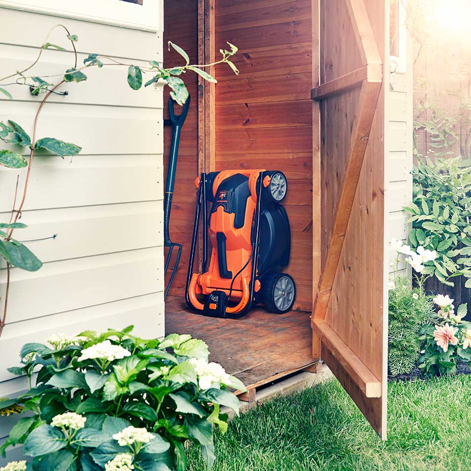LawnMaster 24V cordless mower being stored in garden shed