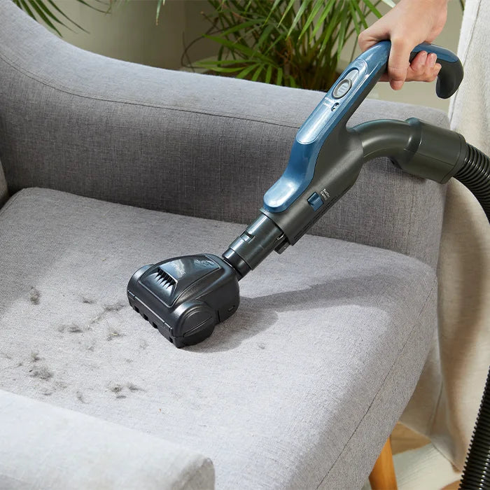 Vacmaster Cylinder Vacuum Cleaner Vortica with Pet Mate Tool on grey chair