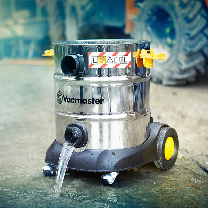 water emptying out of drainage port on industrial wet dust extractor vacuum on construction site