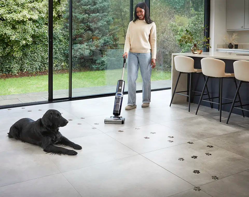 Vacmaster Hard Floor Cleaner mopping and vacuuming dog prints from tiled floor in open plan kitchen diner