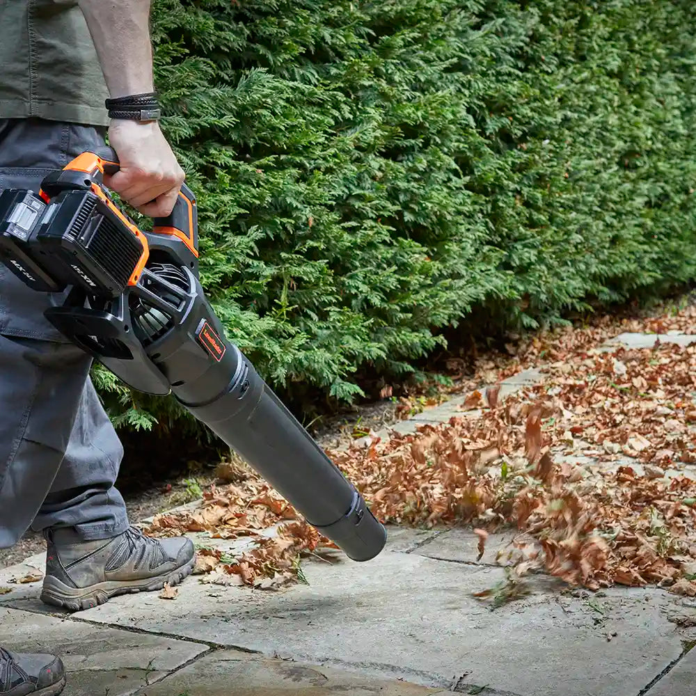 Man blowing leaves on garden path LawnMaster 48V Axial leaf blower
