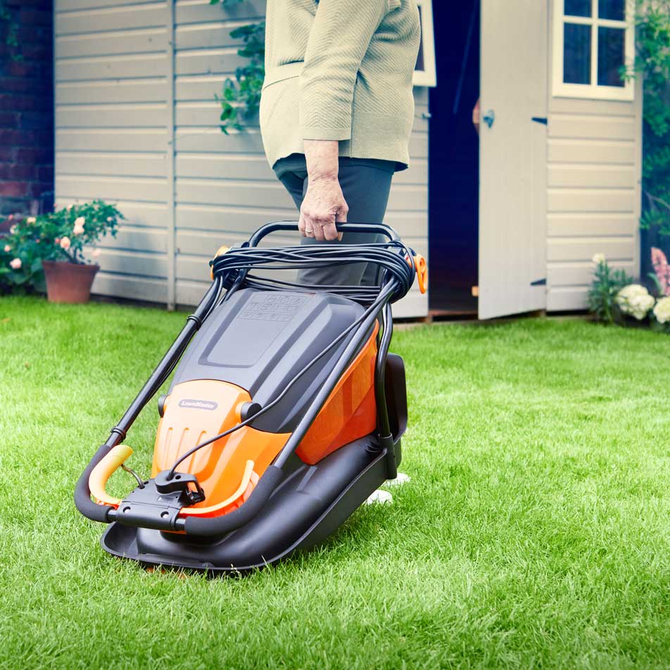 LawnMaster Hover Collect Lawn Mower 1500W 33cm MEH1533 being wheeled across the lawn